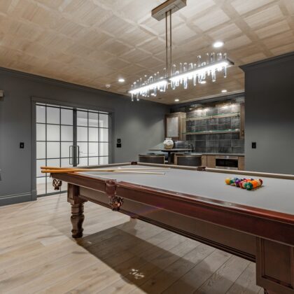 Recreation,Room,With,Large,Wooden,Pool,Table,And,Glass,Doors