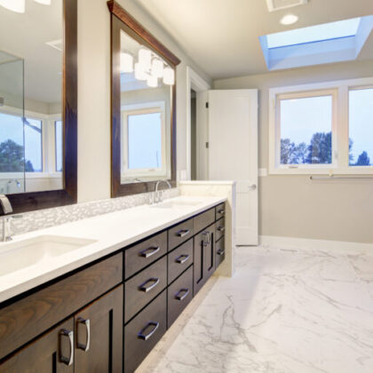 Bright and airy master bathroom features White Modern Double Vanity With Rich Brown Cabinets accented with mosaic backsplash and paired with marble floor. Northwest, USA