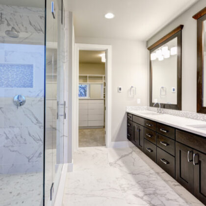 Bright and airy master bathroom features White Modern Double Vanity With Rich Brown Cabinets and marble walk-in shower. Northwest, USA