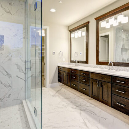 Bright and airy master bathroom features White Modern Double Vanity With Rich Brown Cabinets and marble walk-in shower. Northwest, USA