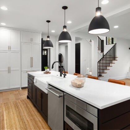 Beautiful white kitchen with dark accents in new modern farmhouse style luxury home