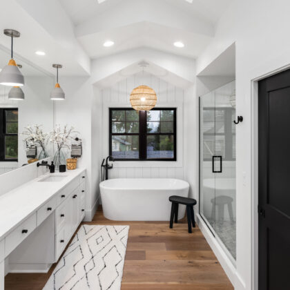 Bathroom in luxury home with double vanity, bathtub, mirror, sinks, shower, and hardwood floor