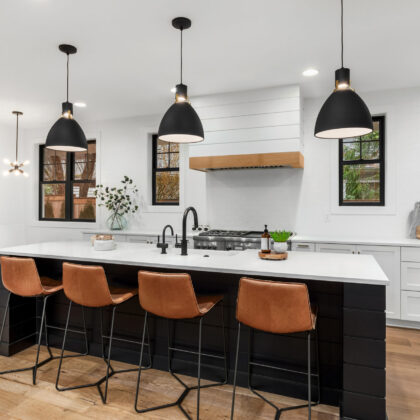 Beautiful white kitchen with dark accents in new modern farmhouse style luxury home