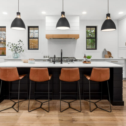 Beautiful white kitchen with dark accents in new modern farmhouse style luxury home