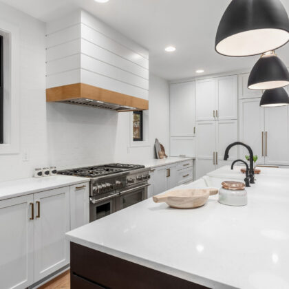 Beautiful white kitchen with dark accents in new modern farmhouse style luxury home