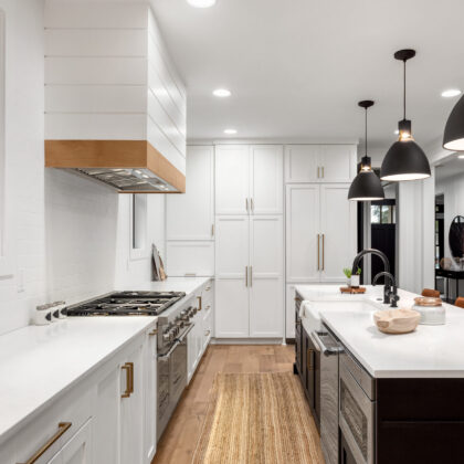 Beautiful white kitchen with dark accents in new modern farmhouse style luxury home