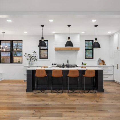 Beautiful white kitchen with dark accents in new modern farmhouse style luxury home