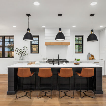 Beautiful white kitchen with dark accents in new modern farmhouse style luxury home